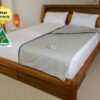 Better Earthing Recovery Bag placed on a bed in a calm bedroom with wooden furniture and soft lighting, used for grounding and EMF shielding to support more restful and uninterrupted sleep.
